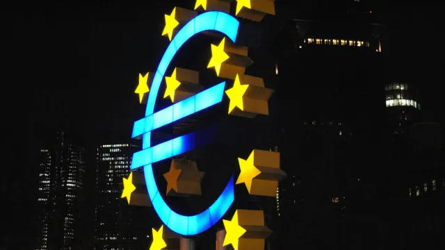 Illuminated euro sign sculpture at night, representing EU financial entities subject to DORA resilience testing