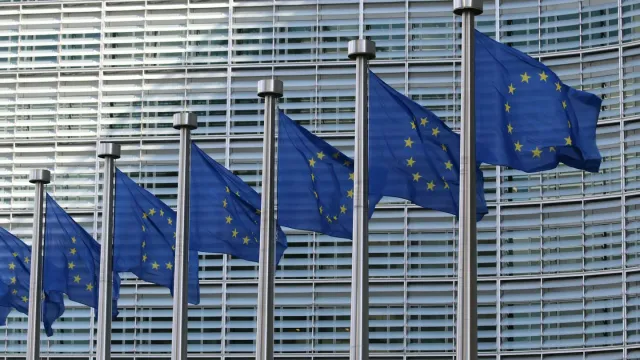 Row of European Union flags outside the European Commission building in Brussels