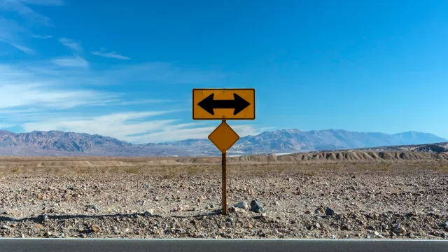 A road sign pointing in two opposite directions, representing a redirect sent to the wrong destination