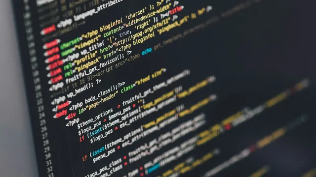 Program source code on a monitor, representing technical vulnerability management under ISO 27001 control A.8.8
